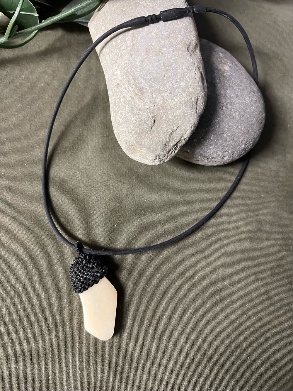 Vintage antique unique shape ivory pendant topped in black stitching, rubber cor